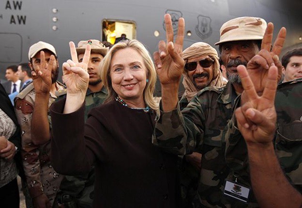 La exsecretaria de estado Hillary Clinton con soldados libios a su salida de Trípoli, en Libia, el 18 de octubre de 2011. (Foto: REUTERS / Kevin Lamarque)
